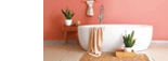 Modern bathtub with towel and houseplants near brown wall