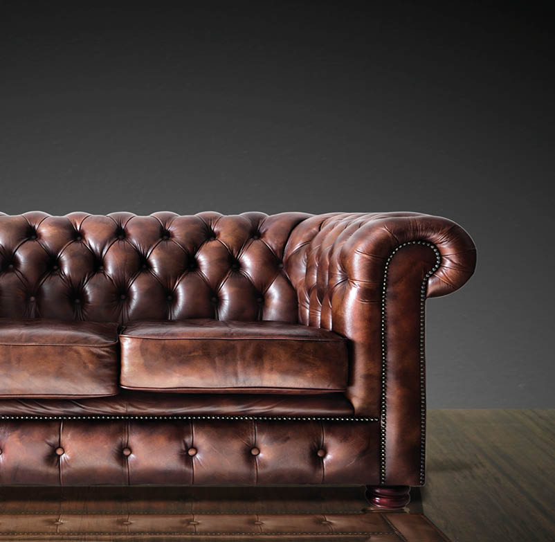 Classic Brown leather sofa on wood in dark room background 