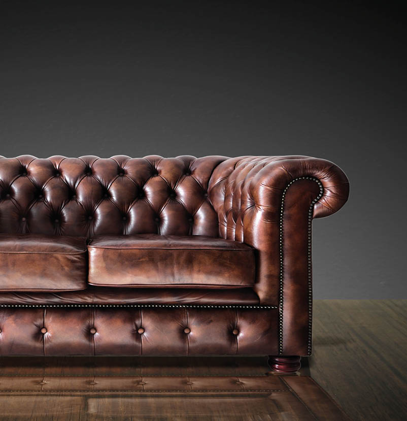 Classic Brown leather sofa on wood in dark room background 